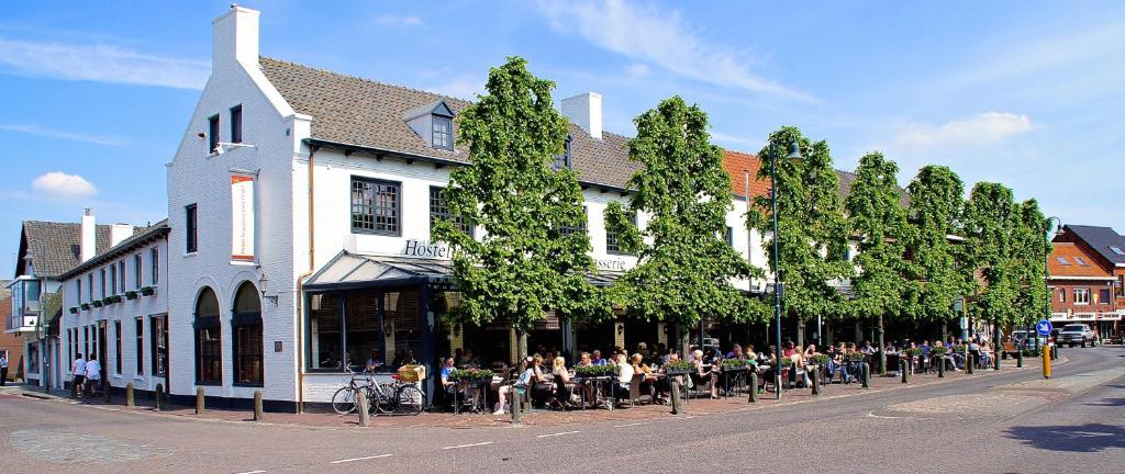 a group of people sitting outside of a building at Hotel Brasserie Den Engel in Baarle-Nassau