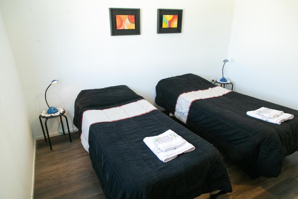 3 camas en una habitación con sábanas negras en Bello Dpto, 20 minutos al Estadio Kempes, cerca de Quality, Hospital Privado, en Córdoba