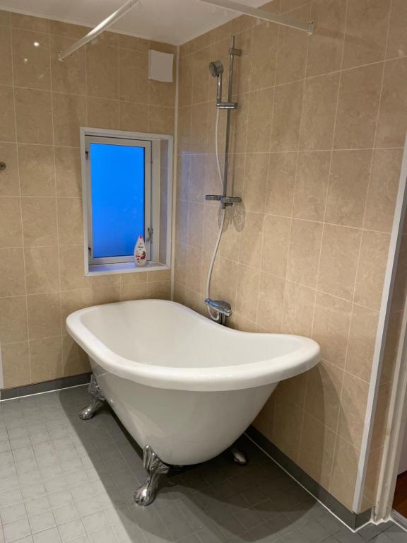 eine weiße Badewanne im Bad mit Fenster in der Unterkunft Villa LA in Landskrona