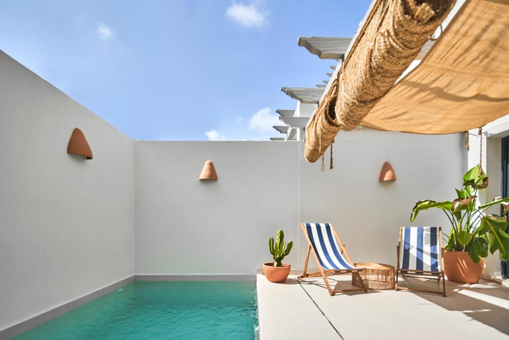 a room with a swimming pool and chairs at Esencia Marbella Casas Boutique in Estepona