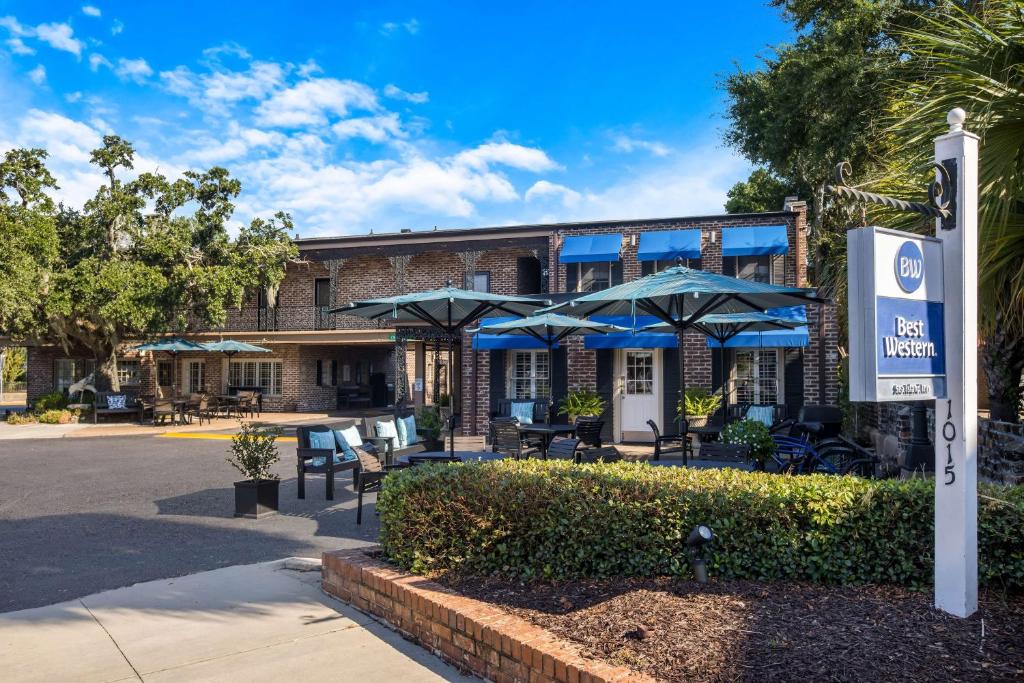 a building with tables and umbrellas in front of it at Best Western Sea Island Inn in Beaufort