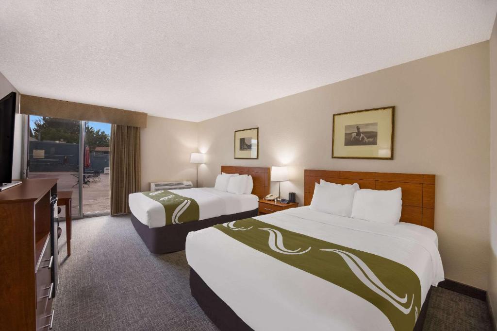 a hotel room with two beds and a balcony at Quality Inn & Suites Canon City in Canon City