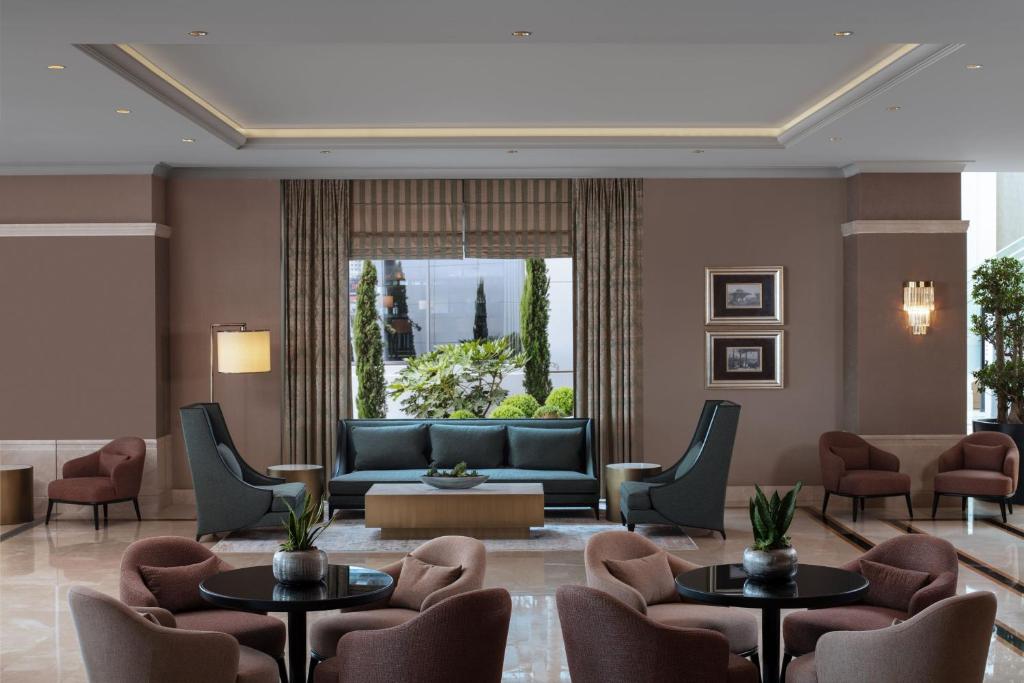 een lobby met een bank en tafels en stoelen bij Istanbul Marriott Hotel Pendik in Istanbul