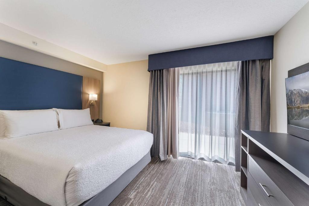 a hotel room with a bed and a large window at SureStay Plus Hotel by Best Western Price in Price