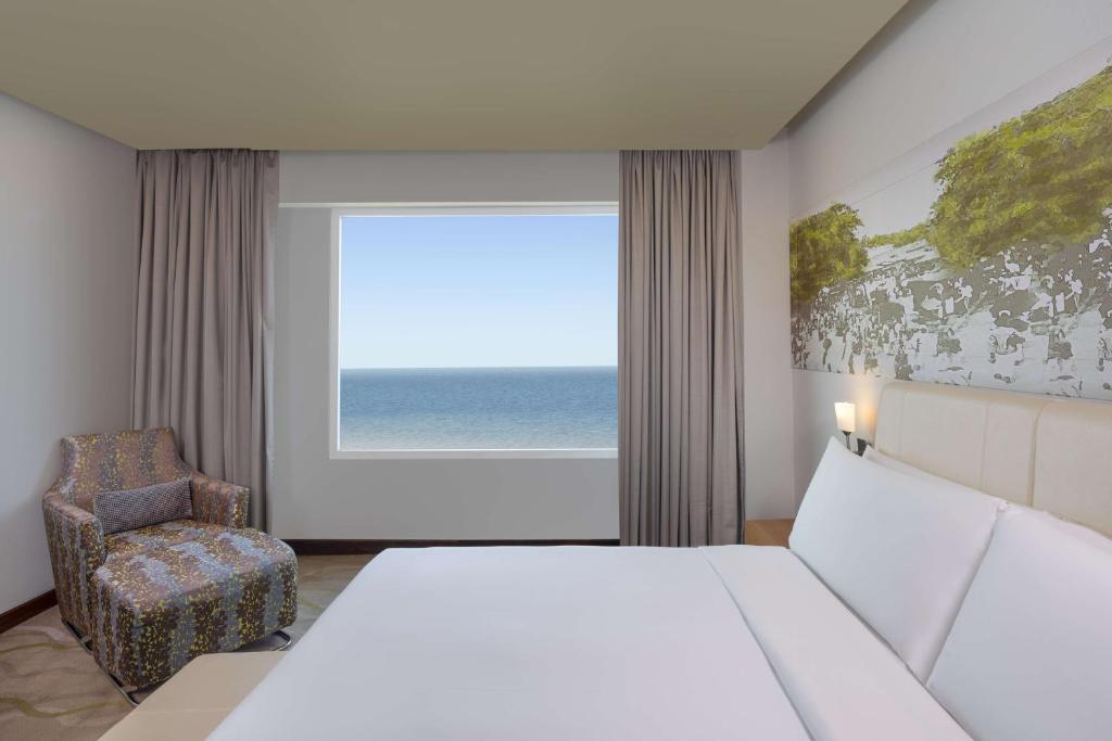 um quarto com uma cama, uma cadeira e uma janela em Radisson Hotel Colombo em Colombo