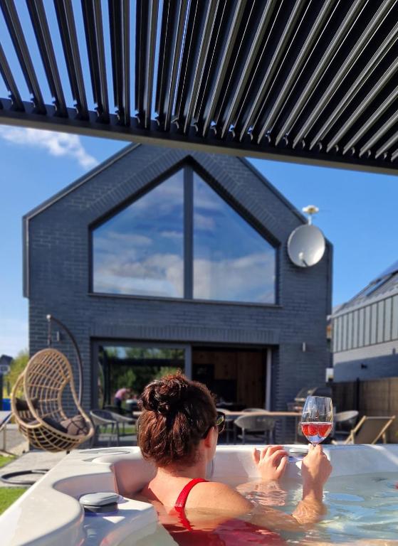 a woman in a hot tub with a glass of wine at odNova - Holiday home with SPA in Bobolin