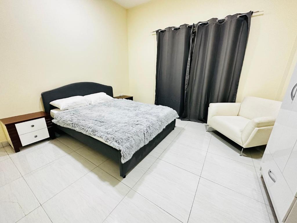 1 dormitorio con 1 cama, 1 sofá y 1 silla en Khalillah's Crib, en Sharjah