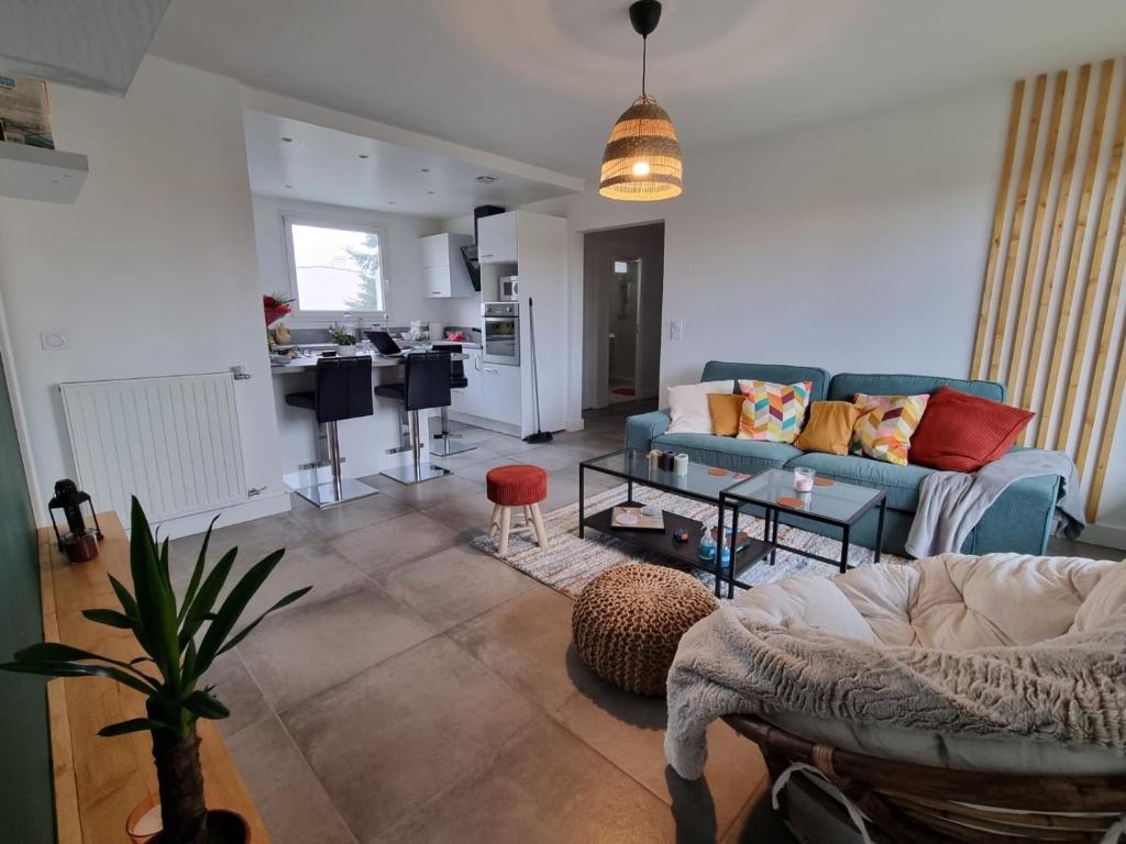 a living room with a blue couch and a kitchen at Cosy Colour Place in Villiers-sur-Marne