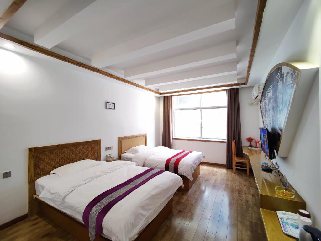 Postel nebo postele na pokoji v ubytování Zhangjiajie Jijiehao Inn