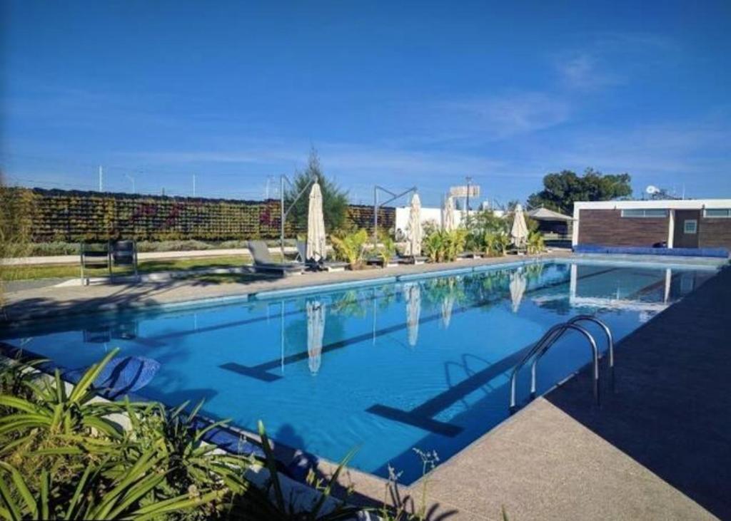 a large swimming pool with blue water at Amplia Casa Moderna c/ Piscina y Lindos Jardines 