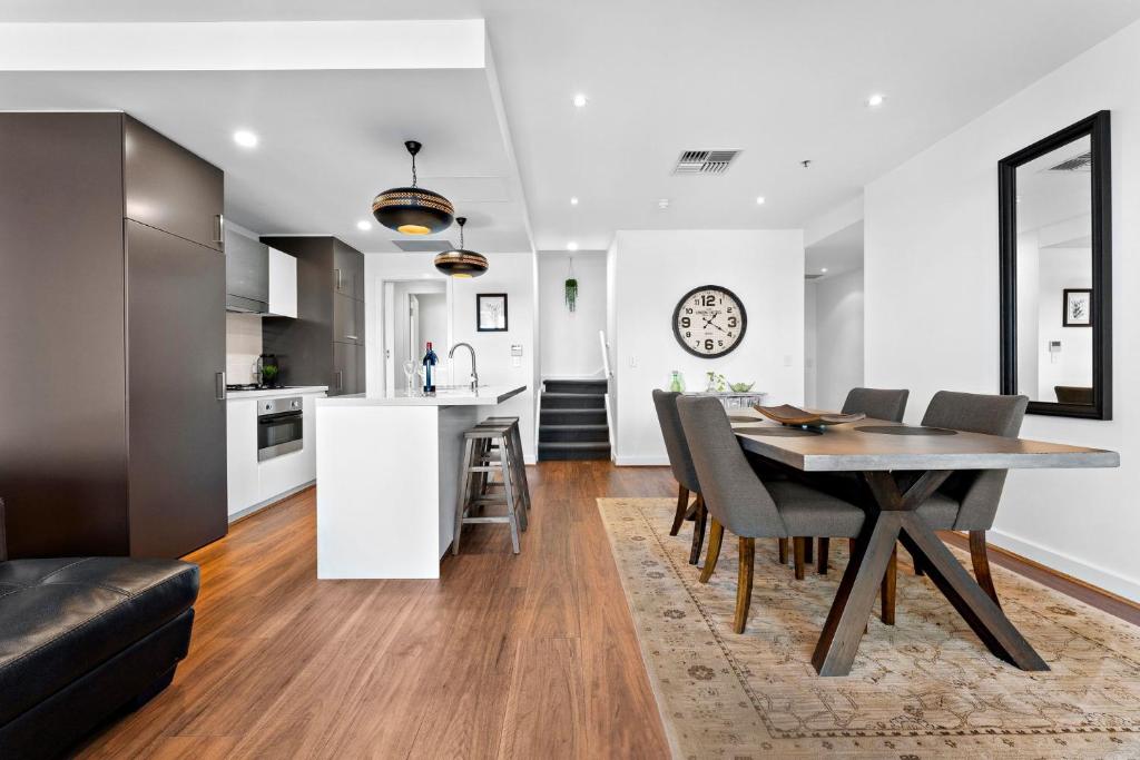 a kitchen and dining room with a table and chairs at Belle Escapes - Beach Retreat Townhouse Glenelg in Glenelg