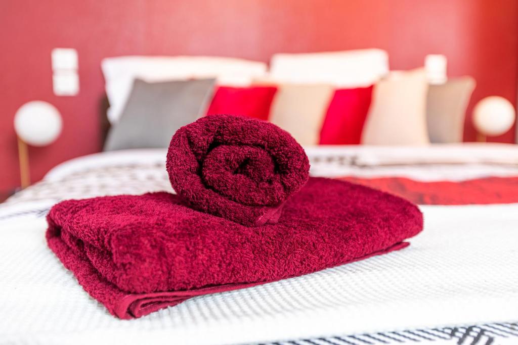 a red towel sitting on top of a bed at Le Sans Souci @Chique@Moderne@Proche du centre-ville 3pieces 2 Chambres in Colmar