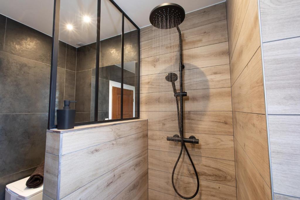 a shower in a bathroom with a wooden wall at Le Sans Souci @Chique@Moderne@Proche du centre-ville 3pieces 2 Chambres in Colmar