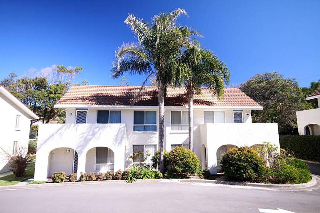 una casa blanca con una palmera delante en Blueys Beach Villa Manyana 14, en Blueys Beach