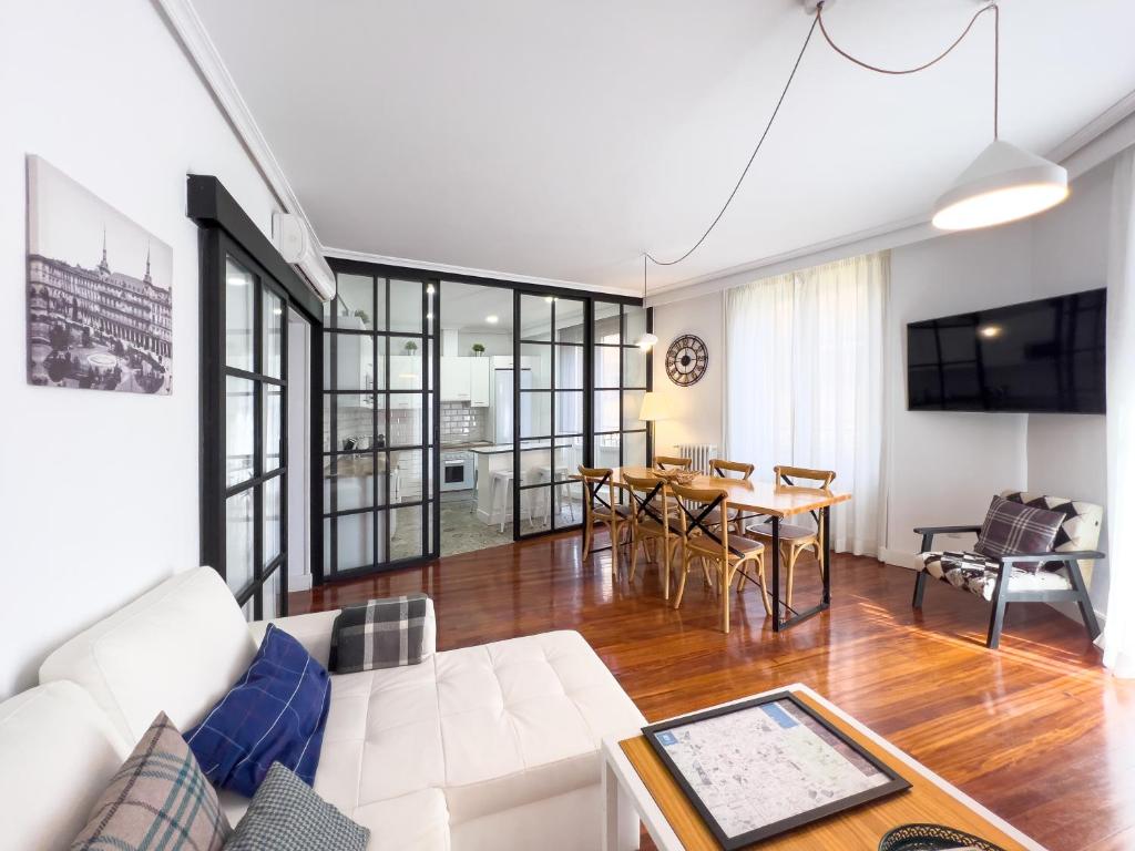 un salon avec un canapé blanc et une table dans l'établissement Callao Suites, à Madrid