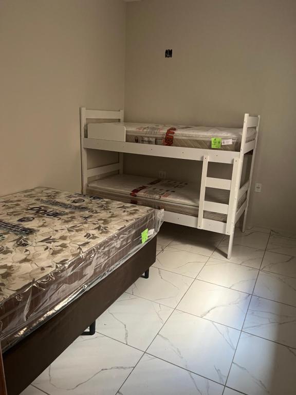 a room with two bunk beds and a bed at Apto térreo Mãe Aparecida 8 pessoas 3km do santuário com WiFi ,ar condicionado nos quartos in Aparecida