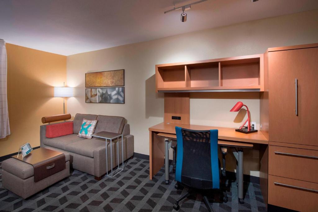 a room with a desk and a chair and a couch at TownePlace Suites by Marriott Atlanta Alpharetta in Alpharetta