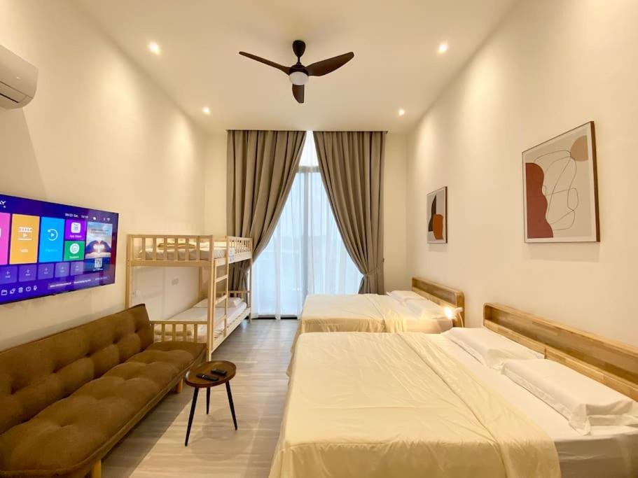 um quarto de hotel com duas camas e um sofá em The Podium@Studio ( 6 pax ) em Kuching
