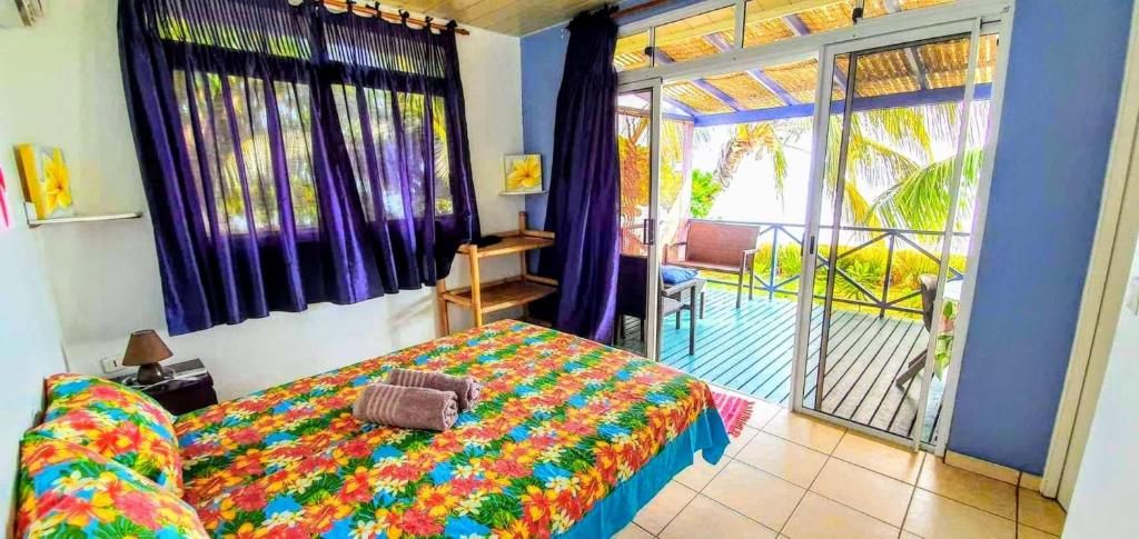 um quarto com uma cama e uma varanda em MOOREA - Fare Taina Nui em Haapiti