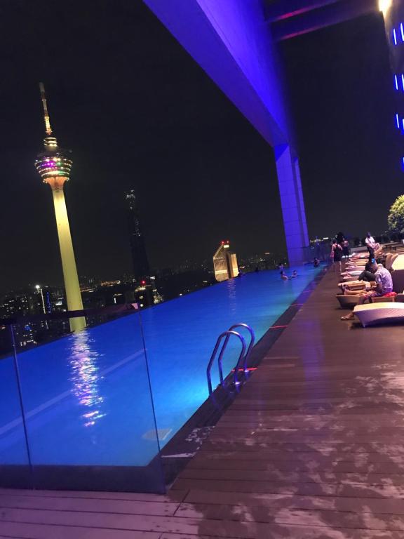 ein Pool auf dem Dach mit Blick auf die Space Needle bei Nacht in der Unterkunft Platinum KLCC &amp; Bukit Bintang in Kuala Lumpur
