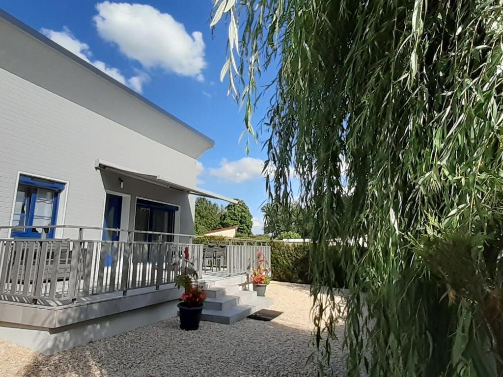 ein weißes Haus mit einem Balkon und einem Baum in der Unterkunft Gîte Villegusien-le-Lac, 3 pièces, 4 personnes - FR-1-611A-17 in Villegusien Le Lac