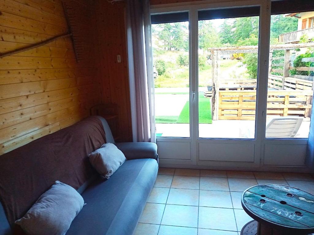 a living room with a couch and a large window at Chalet Le Monêtier-les-Bains, 3 pièces, 6 personnes - FR-1-762-25 in Le Monêtier-les-Bains