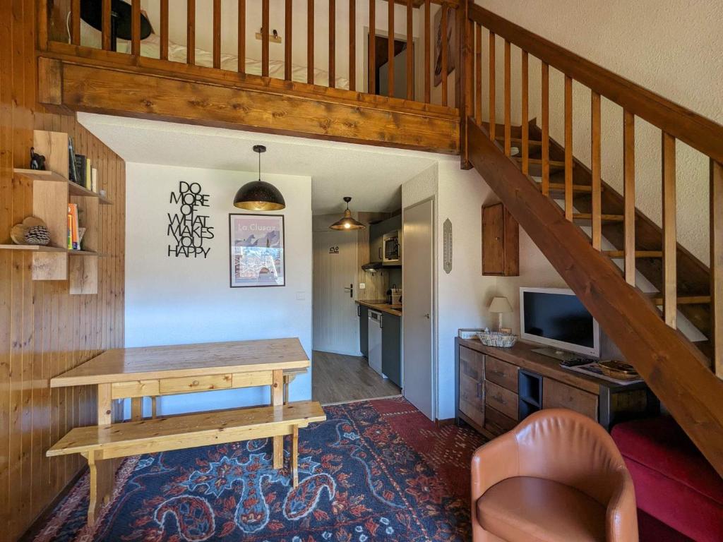 a living room with a table and a staircase at Appartement La Clusaz, 3 pièces, 6 personnes - FR-1-459-211 in La Clusaz