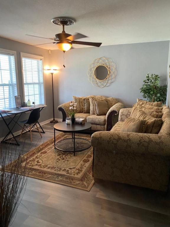 a living room with two couches and a table at Xscapecation Oasis in Tulsa