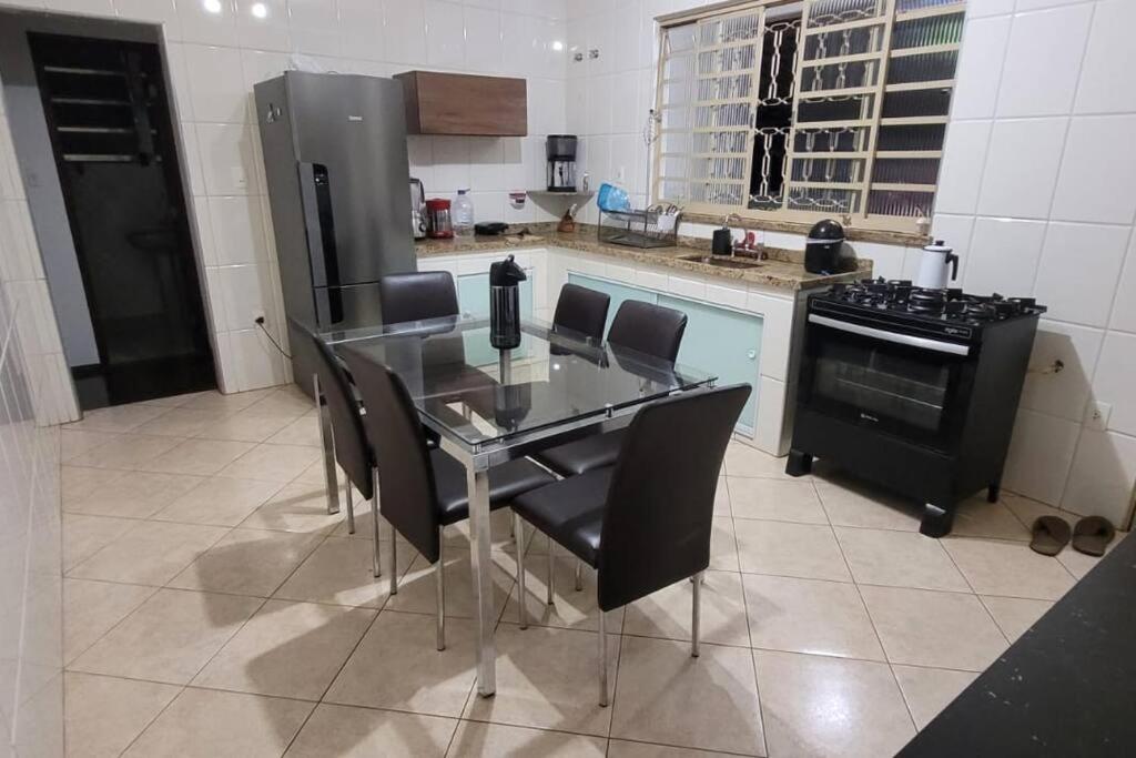 uma cozinha com uma mesa de vidro e electrodomésticos pretos em Casa no Centro de São Lourenço em São Lourenço