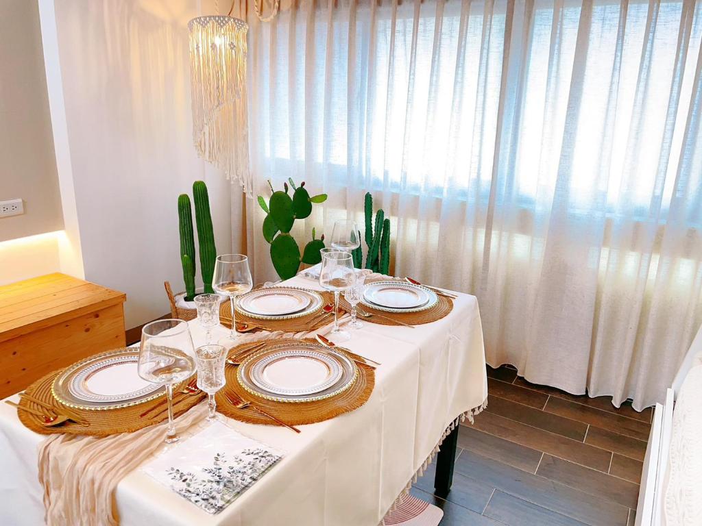 - une table avec des assiettes et des verres à vin dans l'établissement 台南悠然民宿unabnb, à Tainan