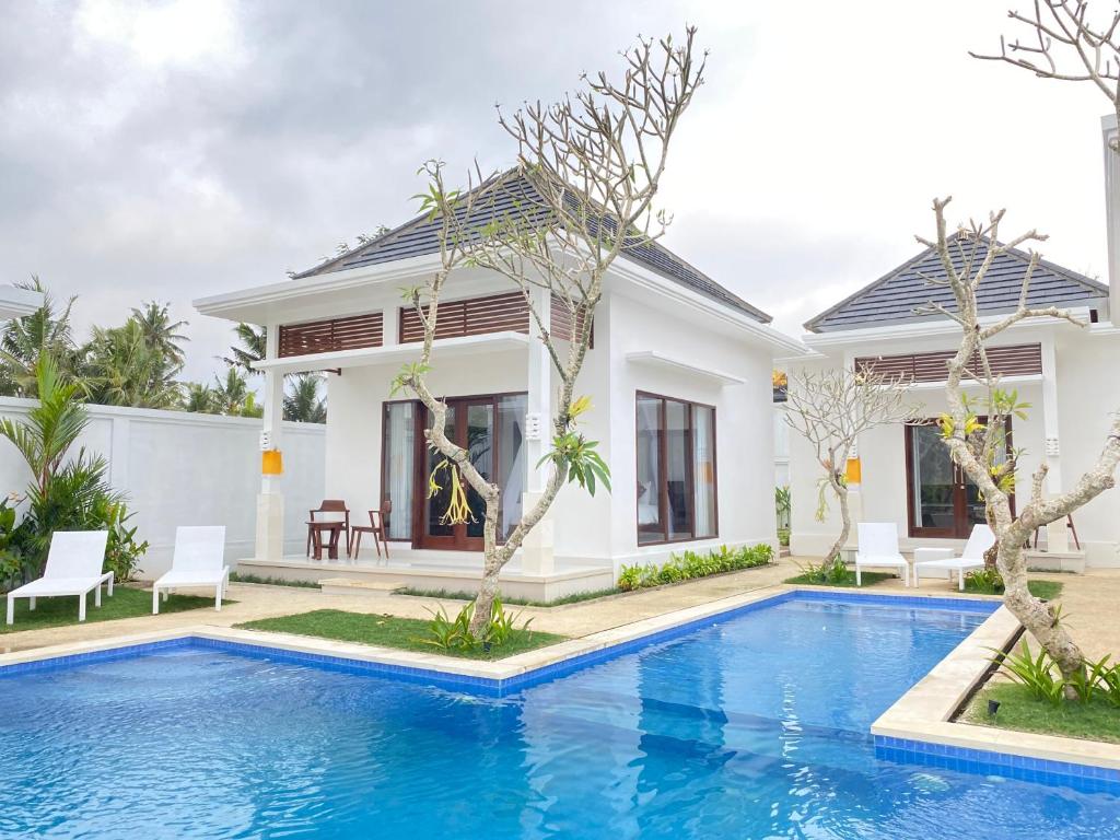 une villa avec une piscine en face d'une maison dans l'établissement Namika Ubud, à Tegalalang