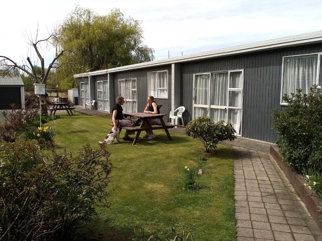 dos mujeres sentadas en una mesa en un patio en Mt Dobson Motel en Kimbell