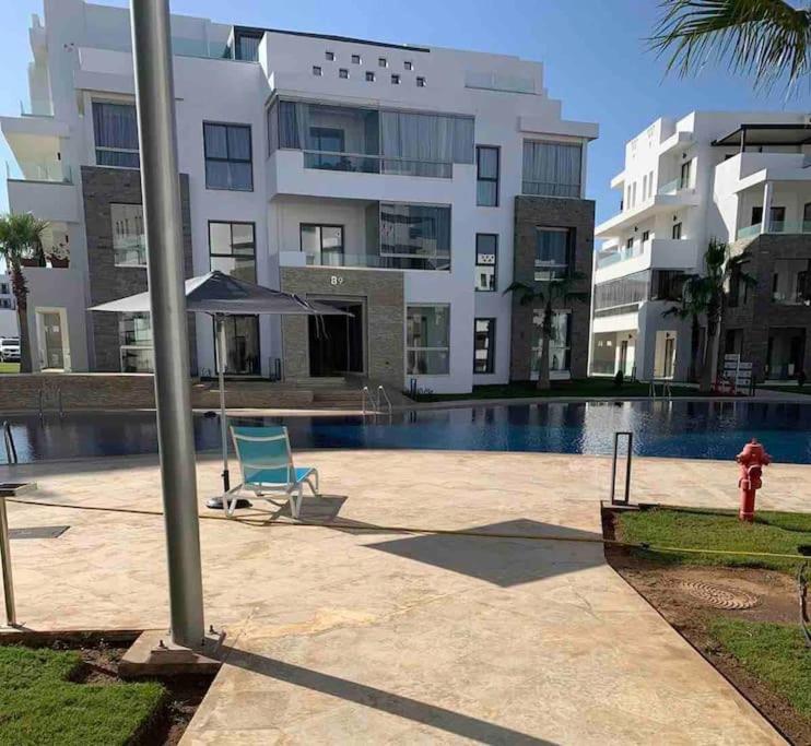 um hidrante ao lado de um edifício com piscina em Luxe résidence Hivernage em Agadir