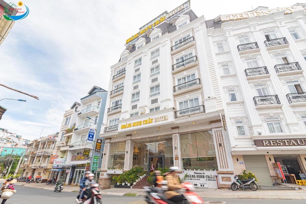 un grupo de personas en motocicleta frente a un edificio en Hoang Minh Chau Ba Trieu Hotel, en Da Lat