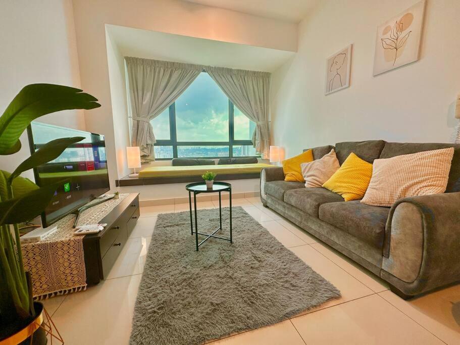 salon z kanapą i dużym oknem w obiekcie Cozy Apartment near Sunway Pyramid Sunway Lagoon w mieście Petaling Jaya