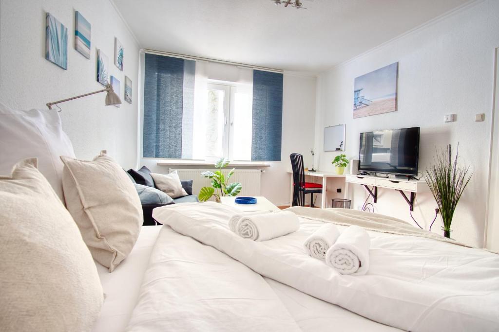 a white room with a bed with towels on it at Homefy Sleep & Relax Apartment mit frei parken, in Toplage in Essen
