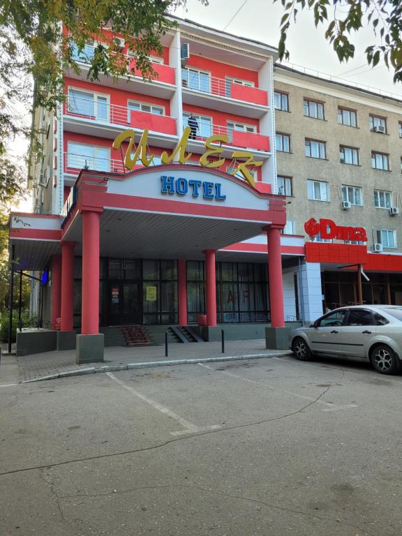 um hotel com um carro estacionado em frente em Гостиница ИЛЕК em Aqtöbe