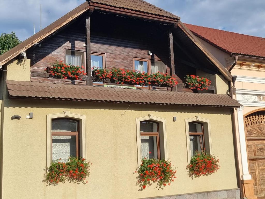 a house with flower boxes on the windows at Apart.5 locuri centru Cristian in Cristian