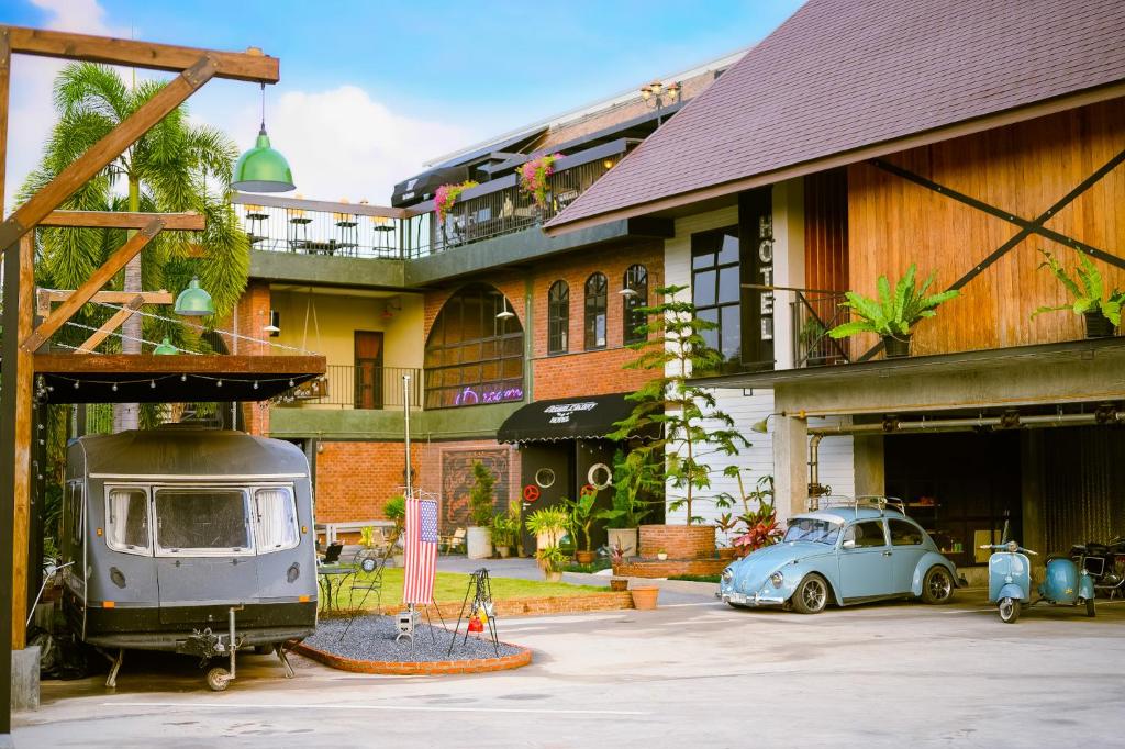 un coche viejo está estacionado frente a un edificio en Dream Factory Hotel, en Udon Thani