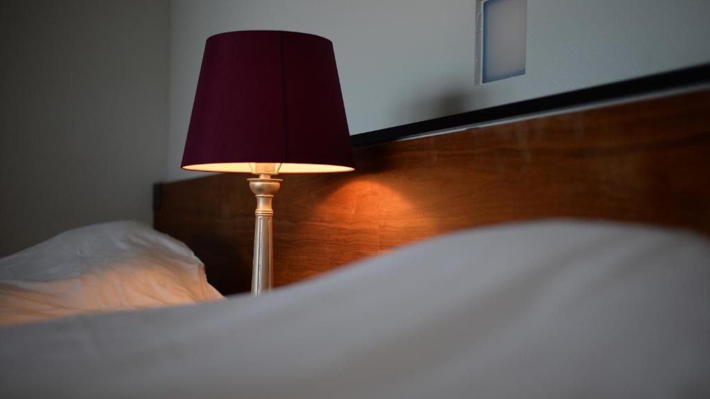 a lamp sitting next to a bed in a bedroom at Fugaku Gunjo in Izu