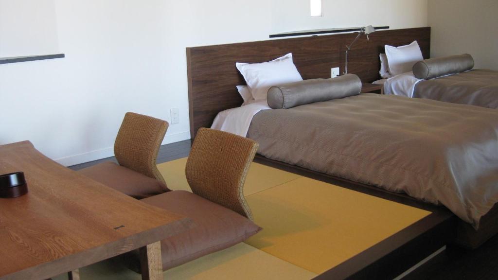 a hotel room with a bed and a table and chairs at Fugaku Gunjo in Izu