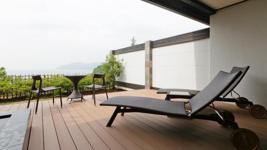 a patio with chairs and a table on a deck at Fugaku Gunjo in Izu