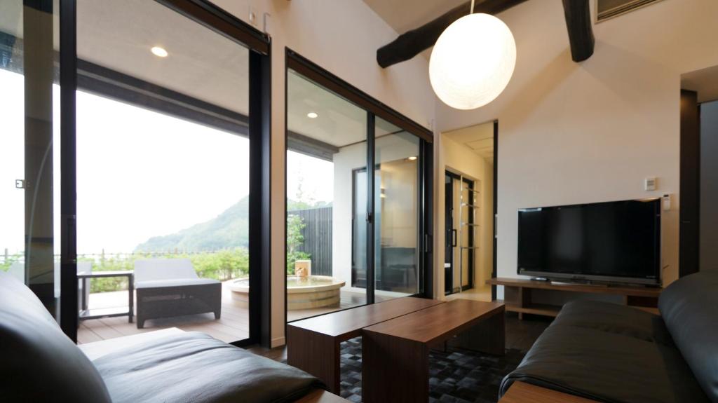a living room with a flat screen tv and a couch at Fugaku Gunjo in Izu
