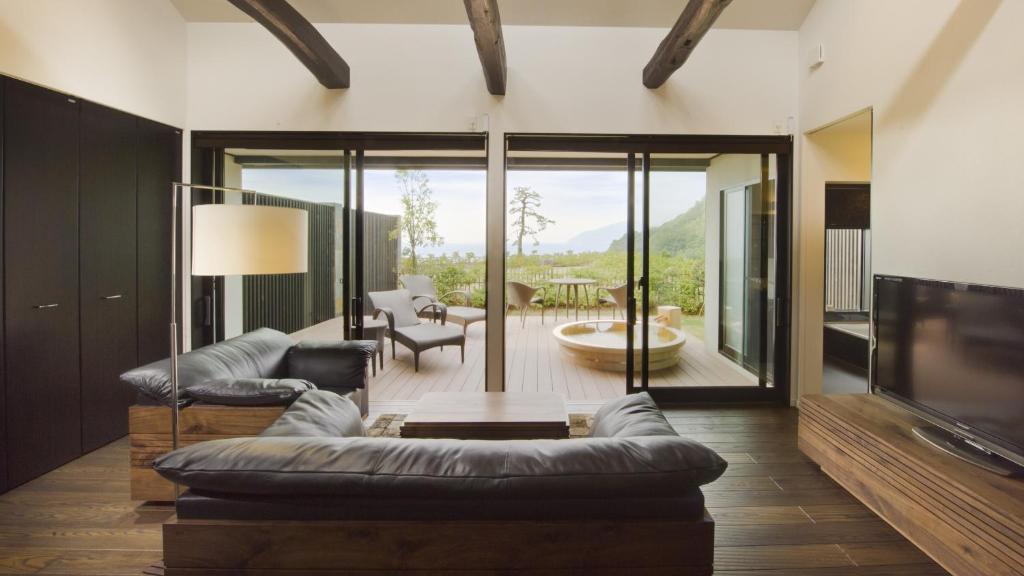 a living room with a couch and a tv at Fugaku Gunjo in Izu