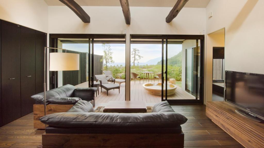 a living room with a couch and a tv at Fugaku Gunjo in Izu