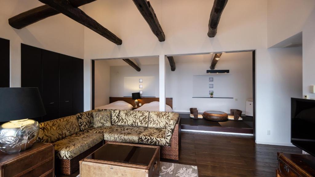 a living room with a couch and a bed at Fugaku Gunjo in Izu