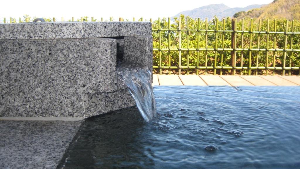 a fountain in the middle of a pool of water at Fugaku Gunjo in Izu