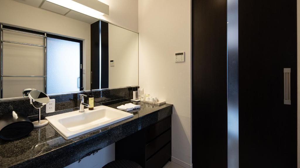 a bathroom with a sink and a mirror at Fugaku Gunjo in Izu
