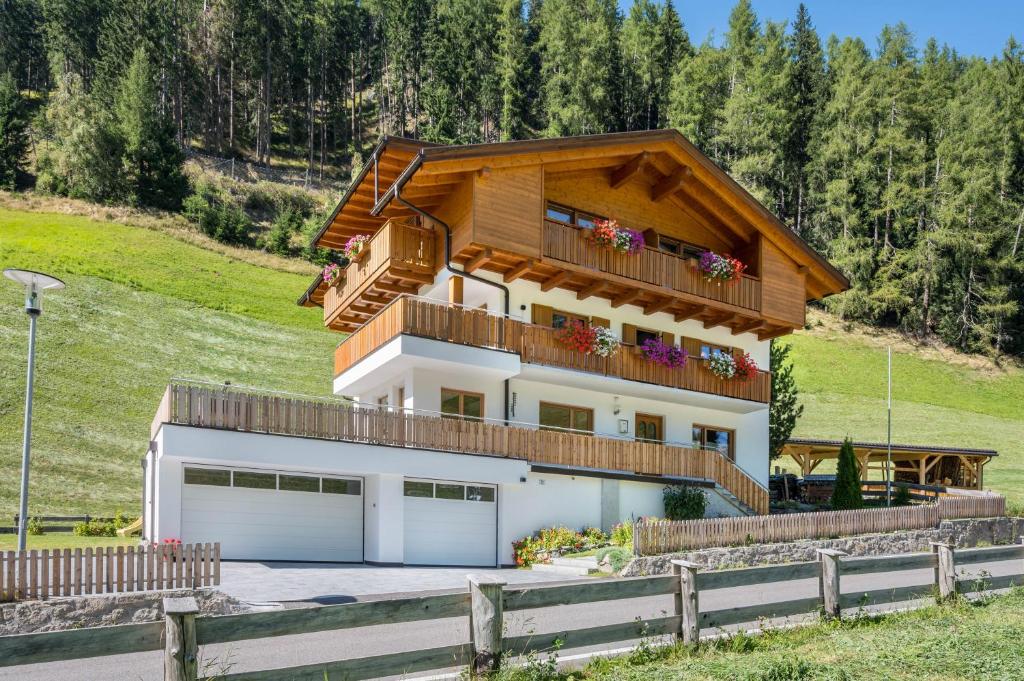 una casa en una colina con balcón en Ferienhaus Nairz Alpenrose, en Predoi