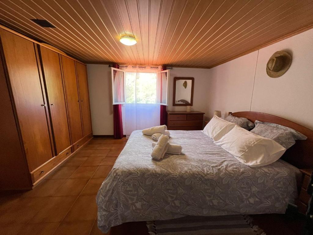 een slaapkamer met een bed met twee handdoeken erop bij Vivenda Ribeiro - Curral das Freiras in Curral das Freiras